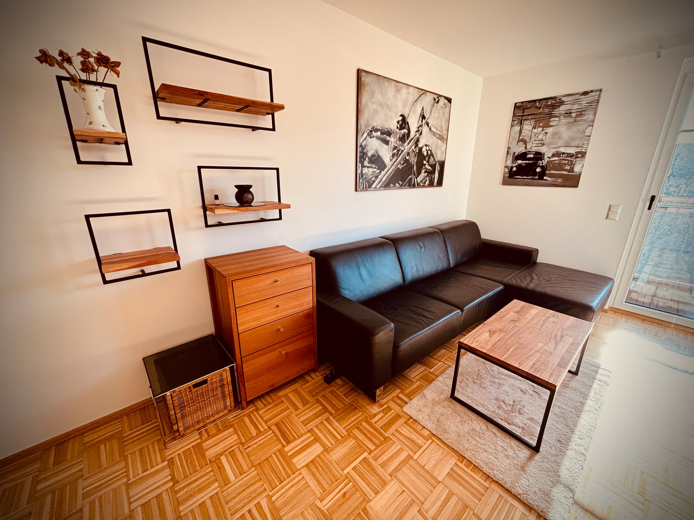Möbliertes Wohnzimmer mit Ledersofa & Holzelementen – 1-Zimmer Apartment zur Kurzzeitmiete, Wohnen auf Zeit 1 bis 6 Monate, Graz | © PP