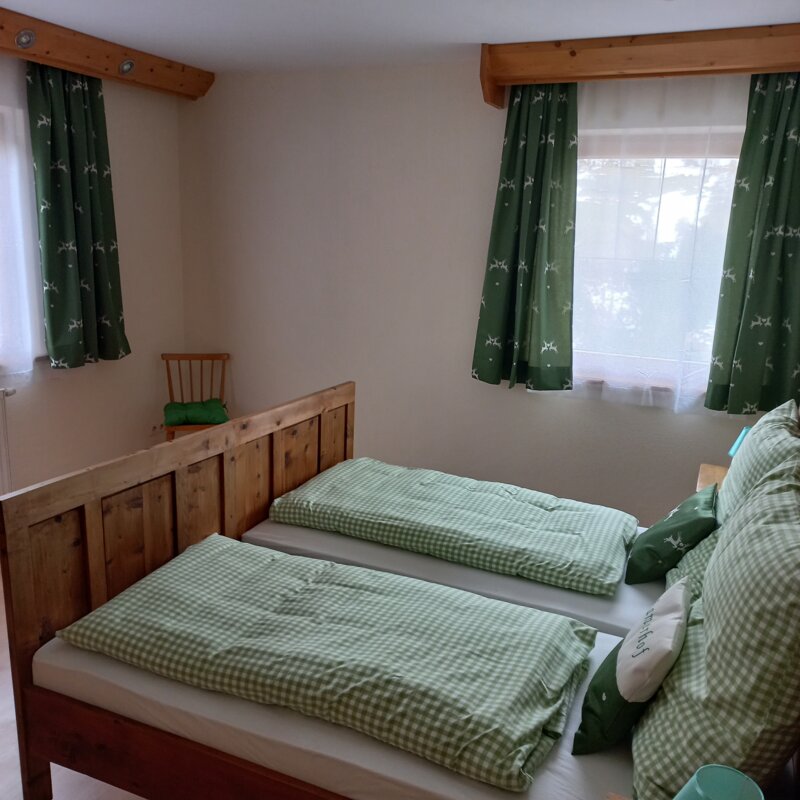 Zirbenbetten und natürliche Materialien zeichnen das grüne als auch das rote Zimmer aus