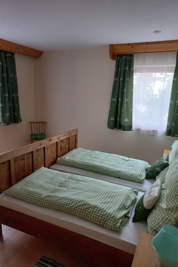 Zirbenbetten und natürliche Materialien zeichnen das grüne als auch das rote Zimmer aus