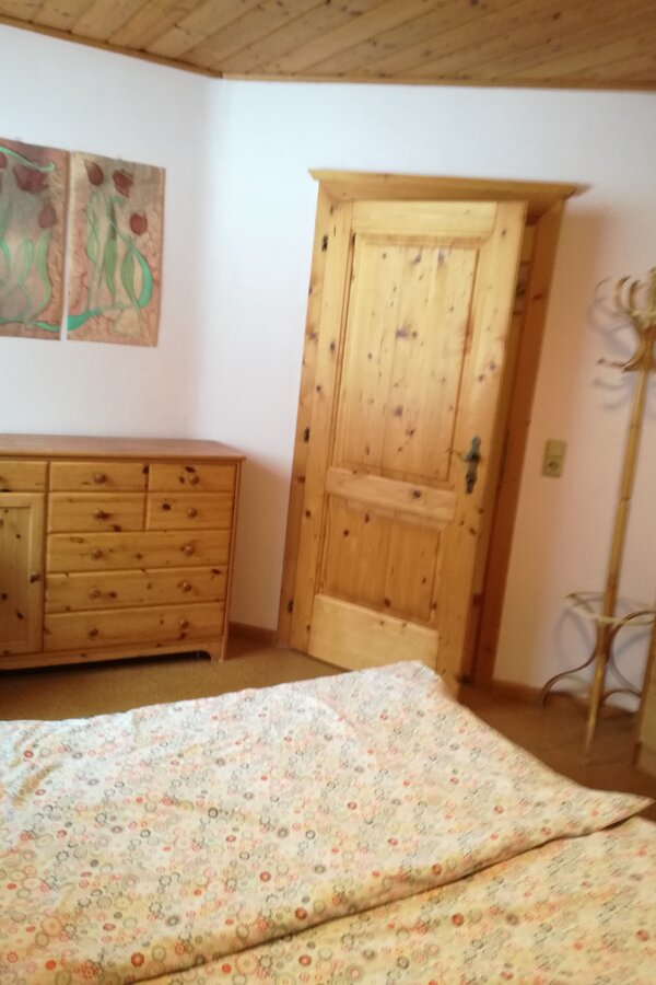 Schlafzimmer mit Bett und Kommode