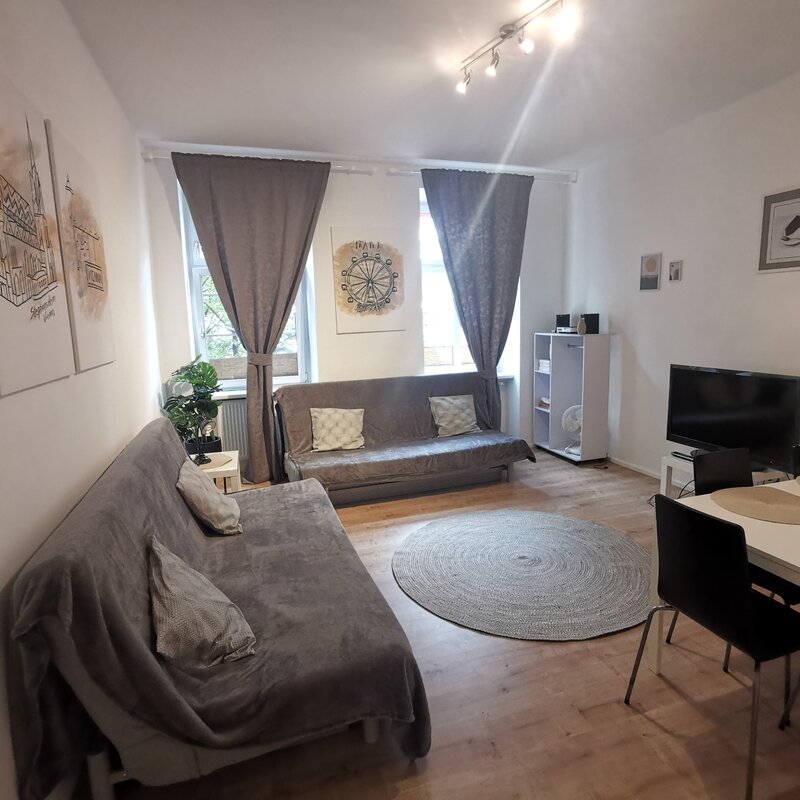 Bright living room with sofa & dining table – 2-room apartment, short-term rental & temporary housing for 1 to 6 months, Vienna | © Pock Christian