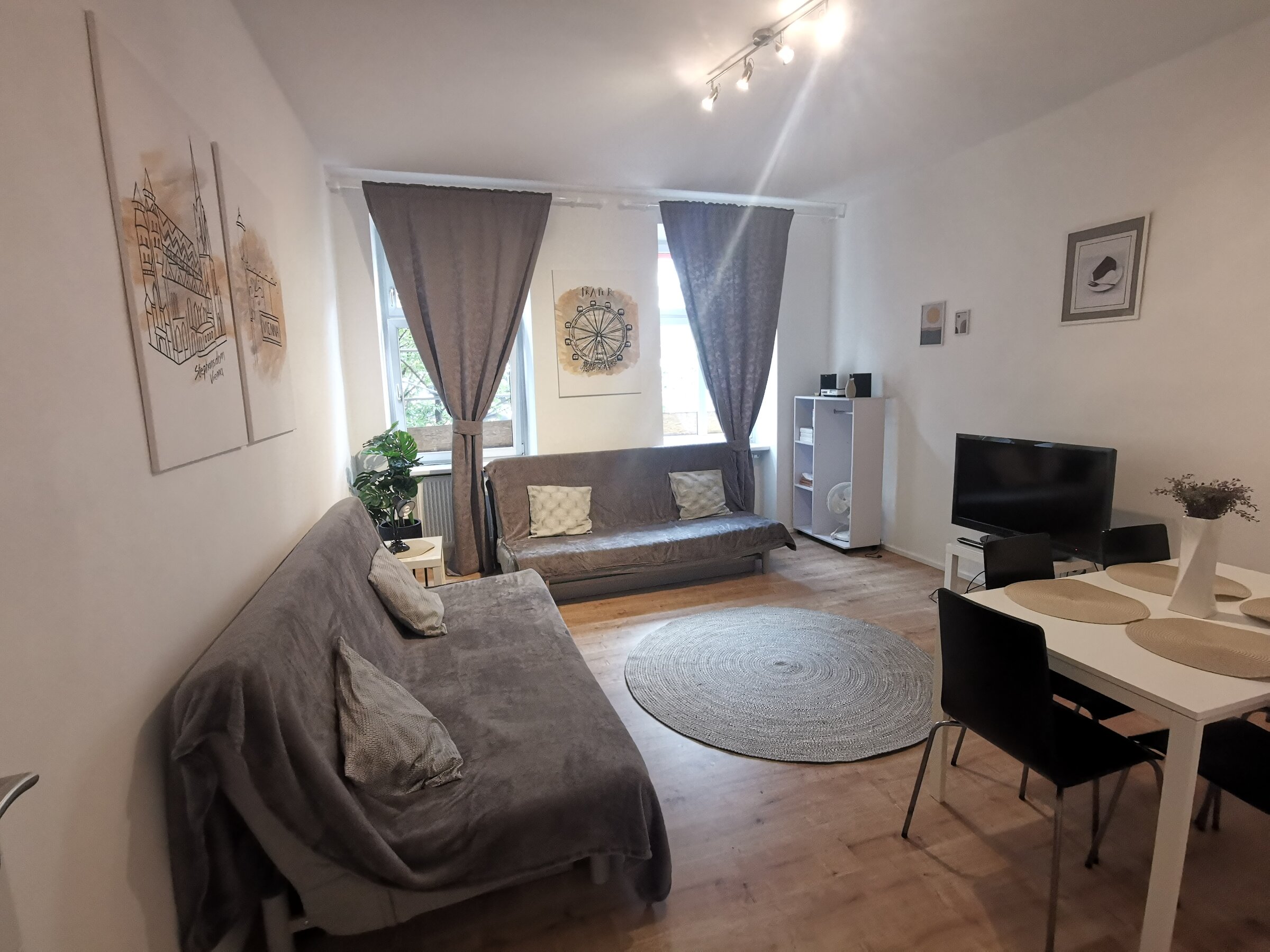 Bright living room with sofa & dining table – 2-room apartment, short-term rental & temporary housing for 1 to 6 months, Vienna | © Pock Christian