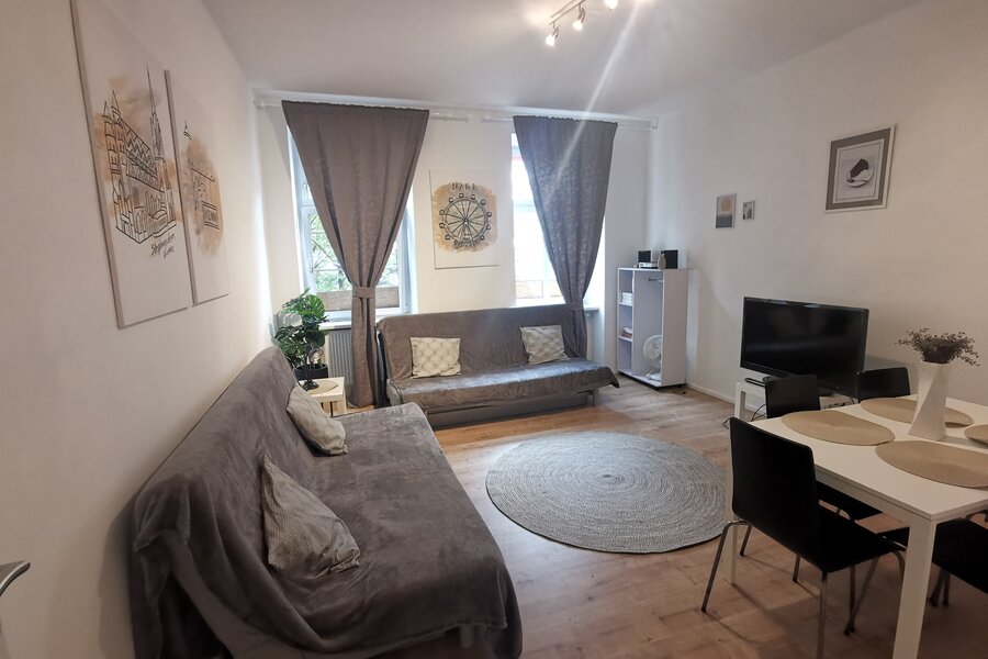 Bright living room with sofa & dining table – 2-room apartment, short-term rental & temporary housing for 1 to 6 months, Vienna | © Pock Christian