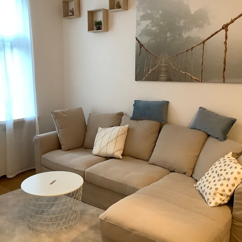 Bright living room with corner sofa & modern decor – 2-room apartment, short-term rental Vienna, 1 to 6 months