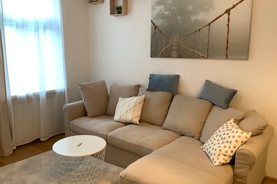 Bright living room with corner sofa & modern decor – 2-room apartment, short-term rental Vienna, 1 to 6 months