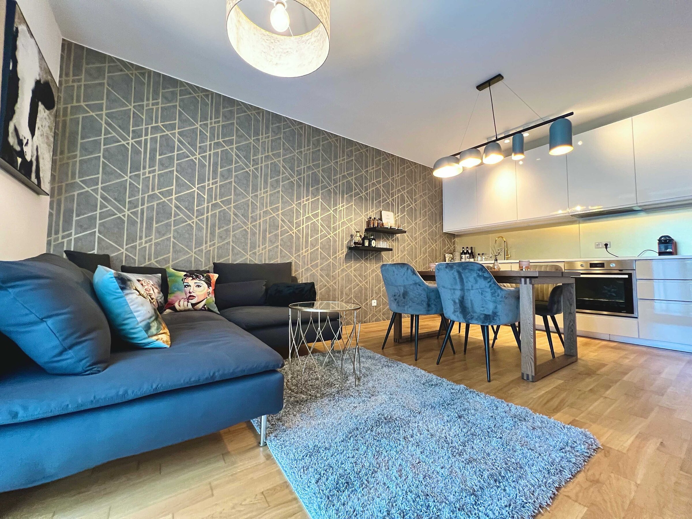 Wohnzimmer mit Sofa, Esstisch und TV