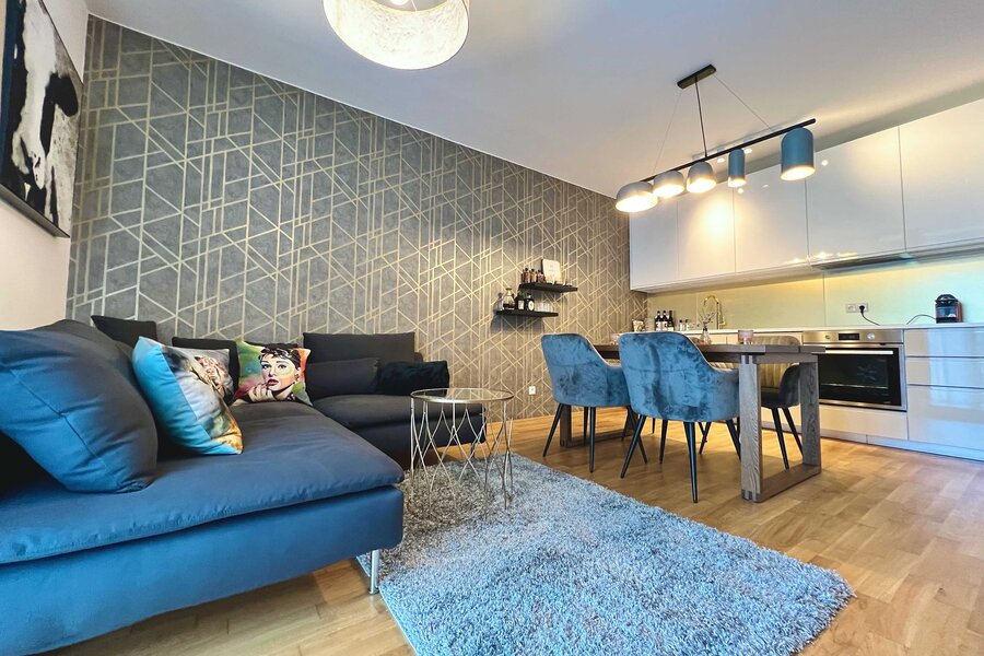 Wohnzimmer mit Sofa, Esstisch und TV