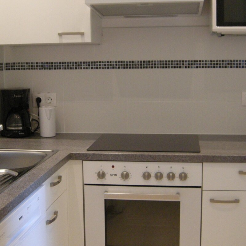 Küche mit Herdplatte, Backofen, Mikrowelle, Kühlschrank, Geschirrspüller