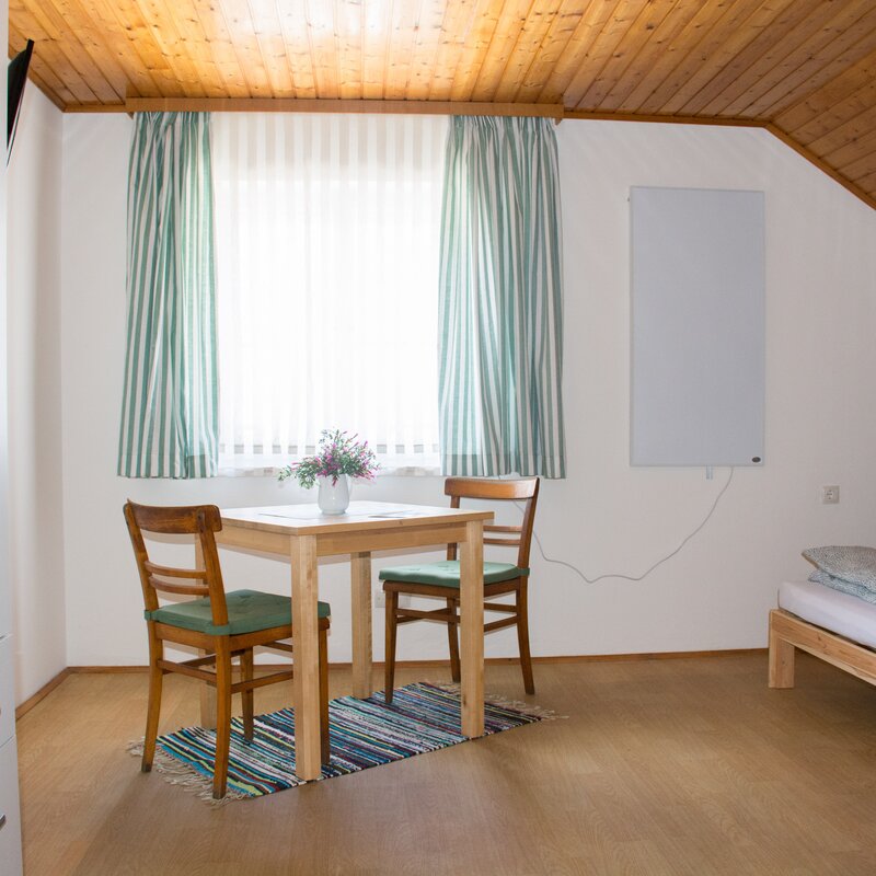 Bright room with wood ceiling & dining table – guesthouse short-term rental & temporary housing for 1 to 6 months in St. Georgen