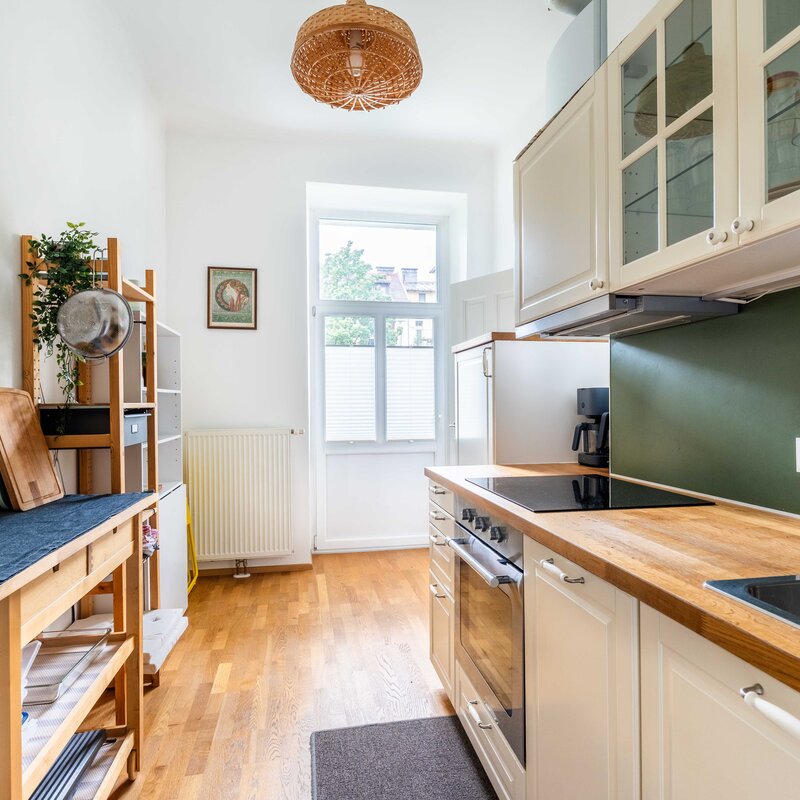 Bright kitchen with wood countertop & green wall – 2-room apartment, short-term rental & temporary housing for 1 to 6 months in Salzburg
