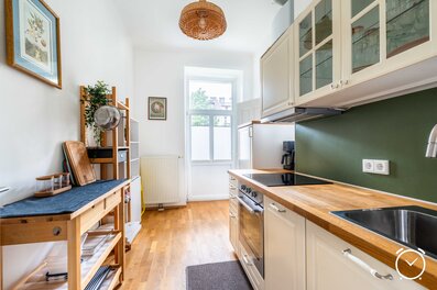 Bright kitchen with wood countertop & green wall – 2-room apartment, short-term rental & temporary housing for 1 to 6 months in Salzburg