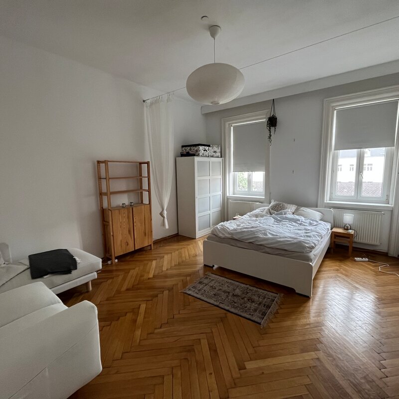 Helles Wohnschlafzimmer mit Fischgrätparkett, möbliert – 1-Zimmer Wohnung zur Kurzzeitmiete in Wien