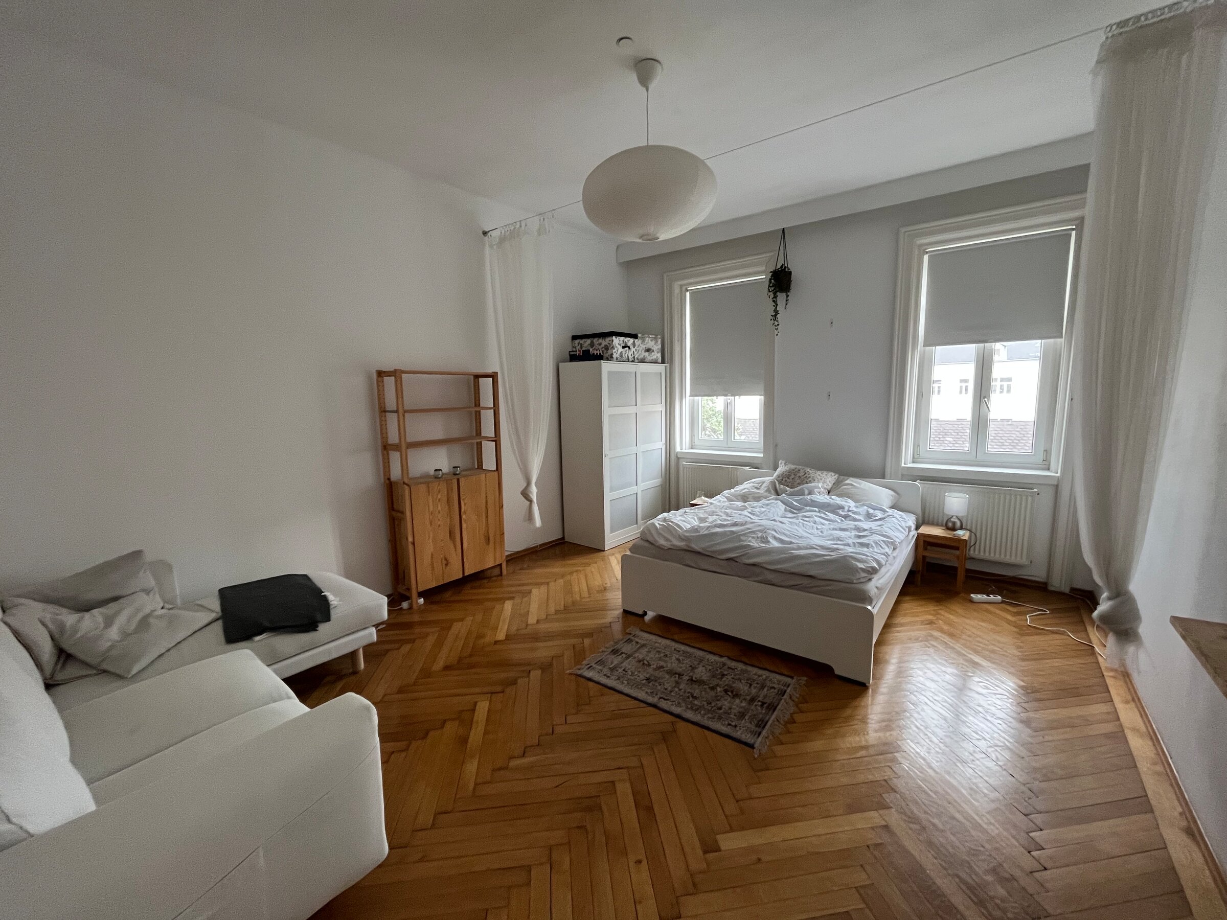 Helles Wohnschlafzimmer mit Fischgrätparkett, möbliert – 1-Zimmer Wohnung zur Kurzzeitmiete in Wien