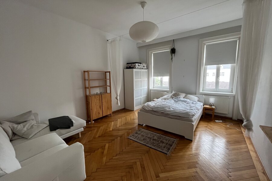 Helles Wohnschlafzimmer mit Fischgrätparkett, möbliert – 1-Zimmer Wohnung zur Kurzzeitmiete in Wien