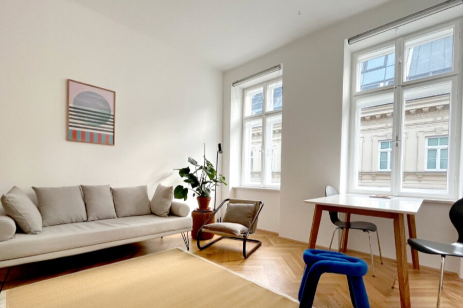 Helles Wohnzimmer mit Sofa & Arbeitsplatz – 1-Zimmer Wohnung zur Kurzzeitmiete & Wohnen auf Zeit für 1 bis 6 Monate in Wien | © Patrizia Zobernig