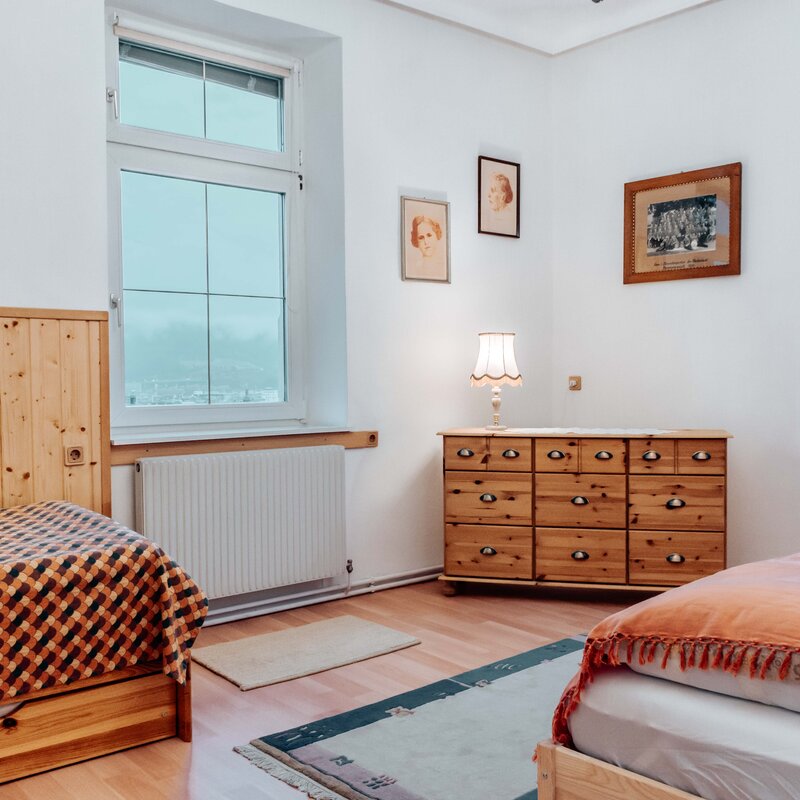 Bright bedroom with wooden furniture – 2-room apartment, short-term rental & temporary housing for 1 to 6 months in Innsbruck
