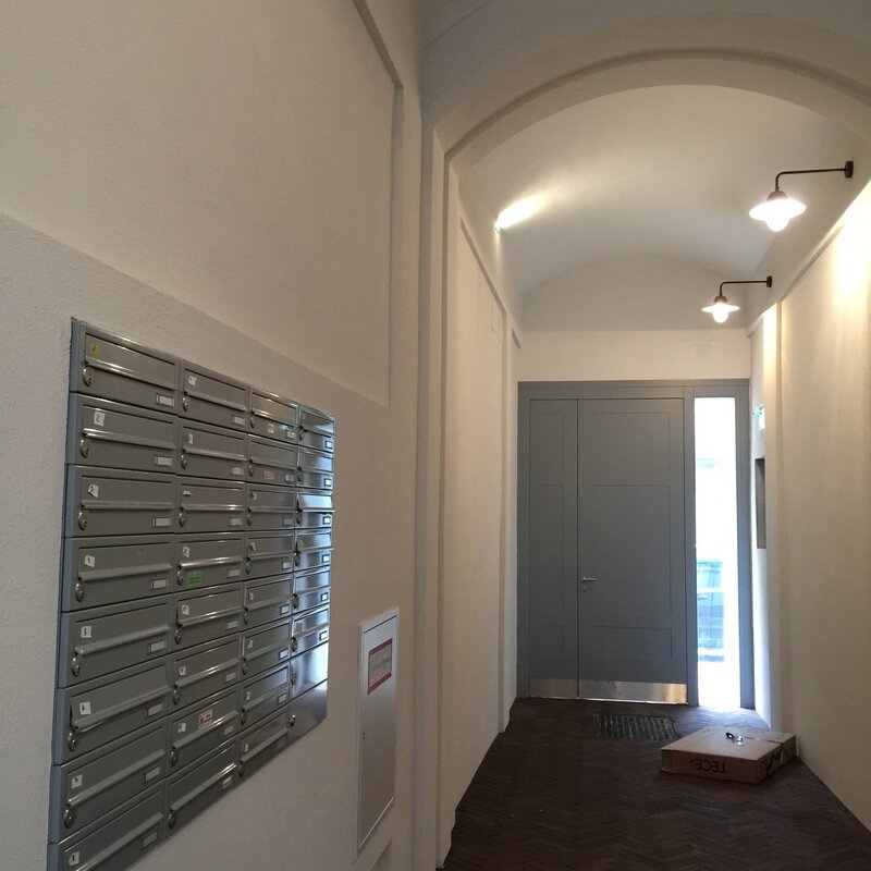 Eingangsflur zum Innenhof mit mit automatischen Flurlampen und Briefkästen | © Jeanne Szilit