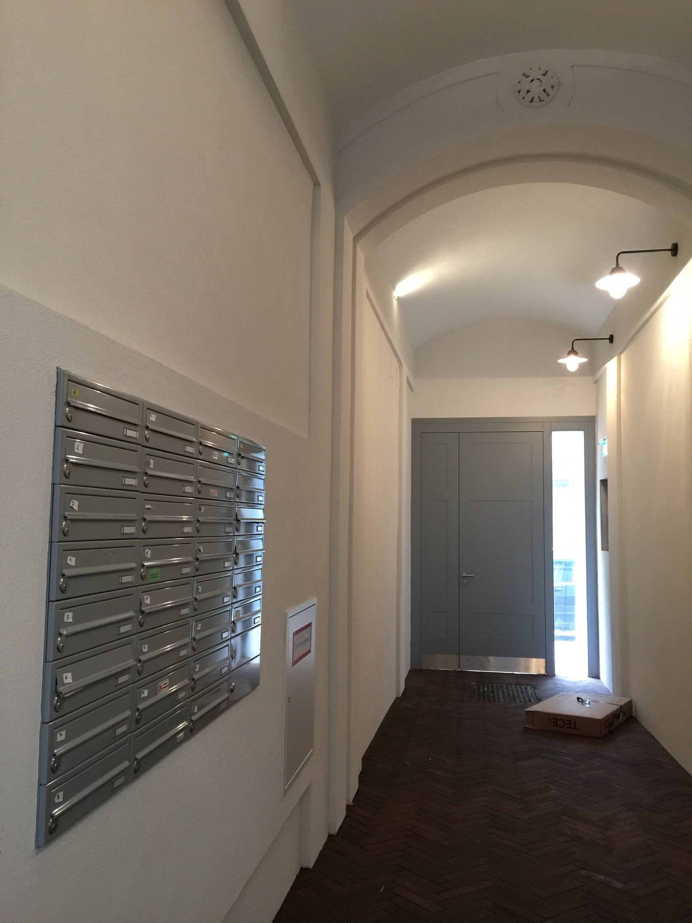 Eingangsflur zum Innenhof mit mit automatischen Flurlampen und Briefkästen | © Jeanne Szilit