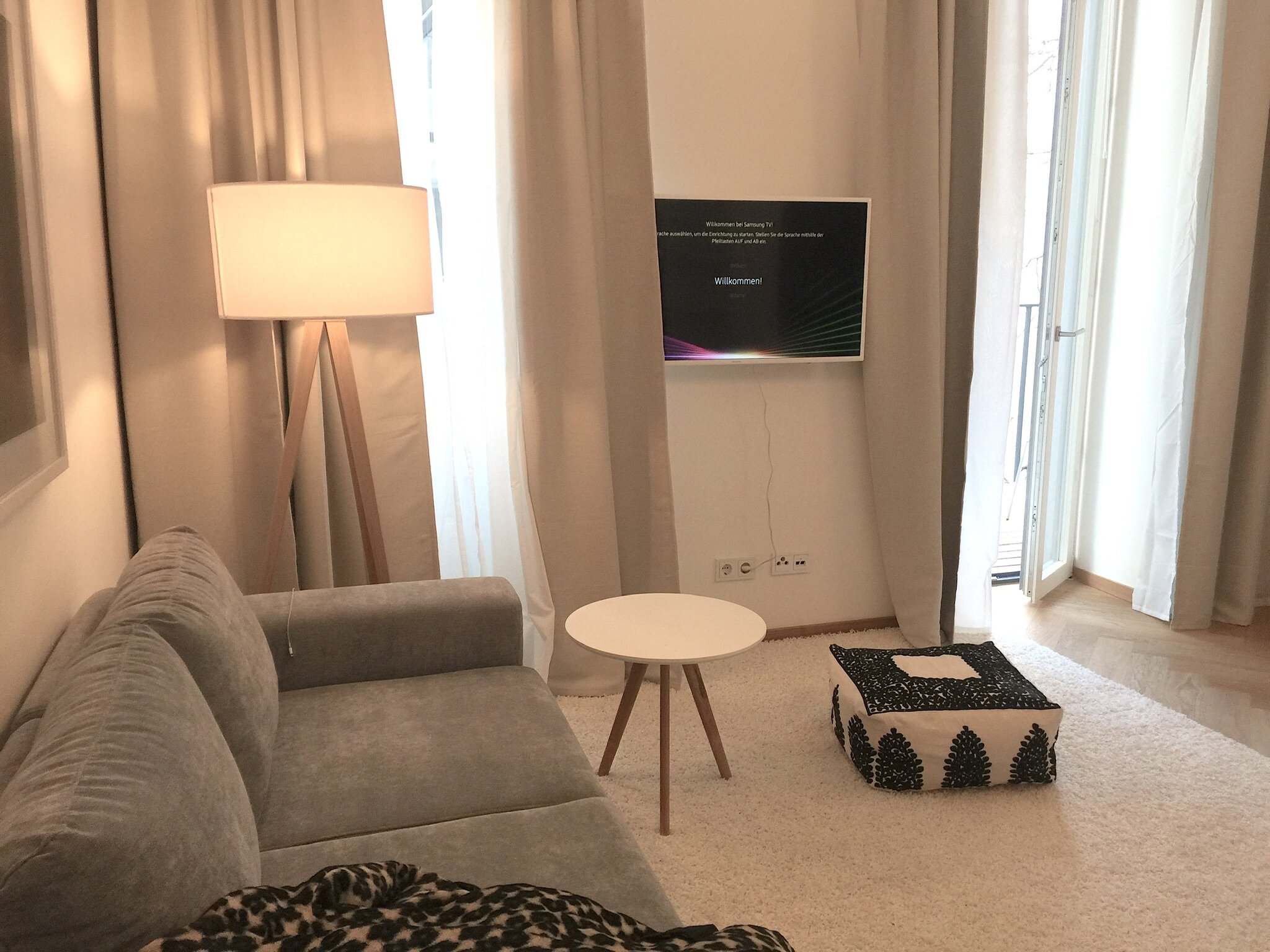Salon with Couch and TV / WLAN, small table and floor cushion from Maroc, Balcony door | © Jeanne Szilit