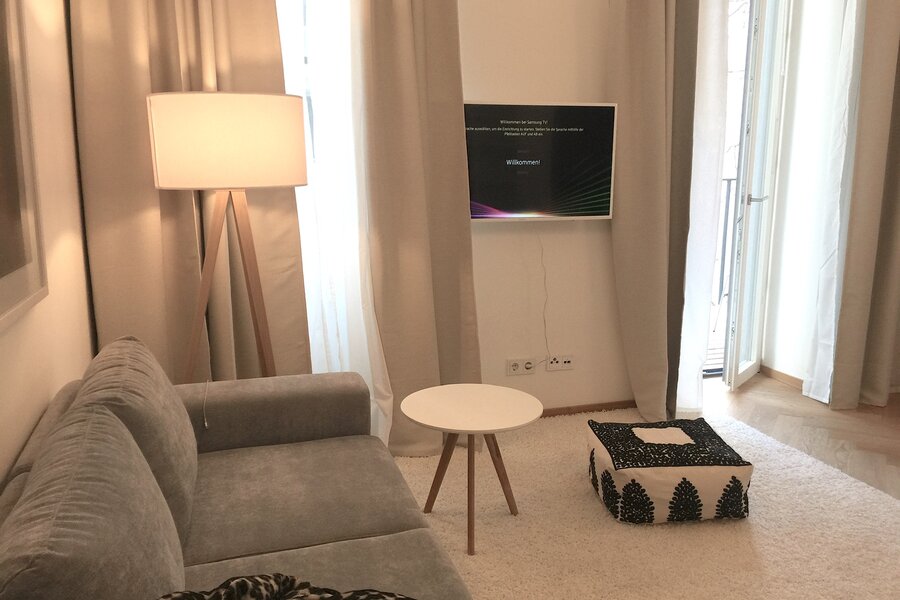 Salon with Couch and TV / WLAN, small table and floor cushion from Maroc, Balcony door | © Jeanne Szilit