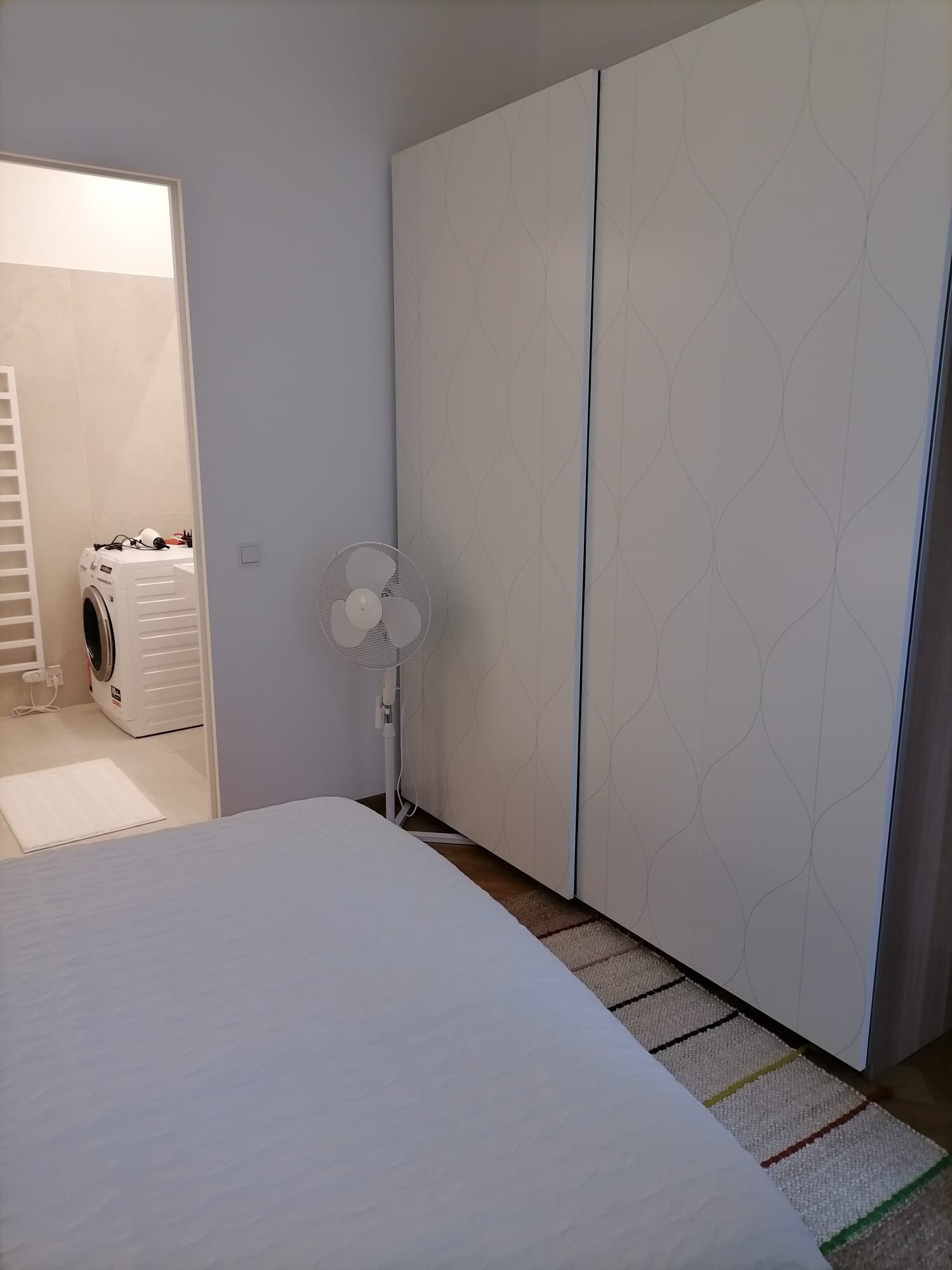Schlafzimmer mit Badzugang, Waschtrockner, Ventilator und grossem Schrank mit Schiebetüren | © Jeanne Szilit