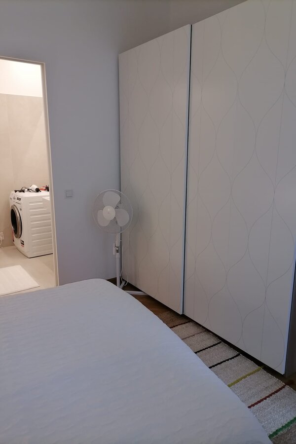 Schlafzimmer mit Badzugang, Waschtrockner, Ventilator und grossem Schrank mit Schiebetüren | © Jeanne Szilit