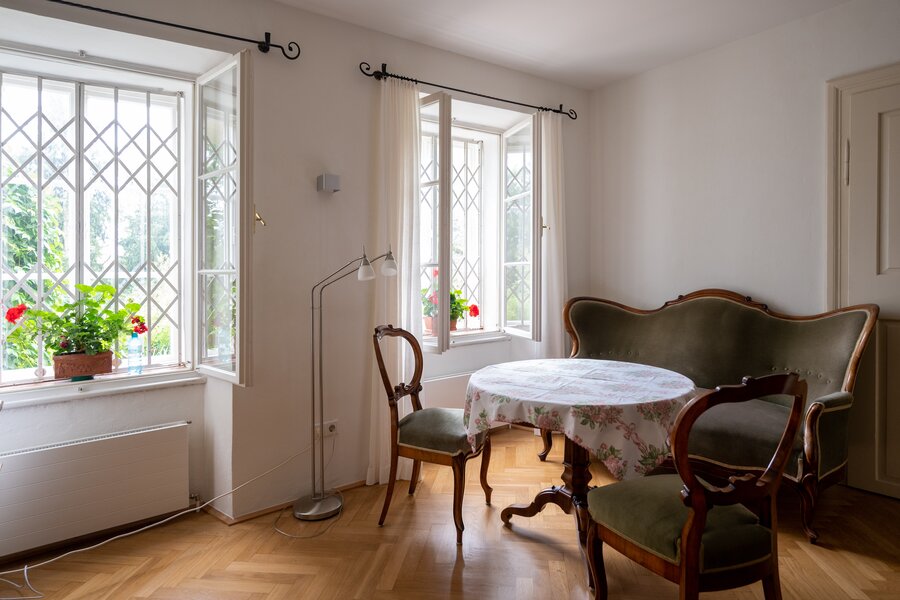 Heller Wohnbereich mit Antikstühlen & Rautensprossfenstern – 2-Zimmer Wohnung, Kurzzeitmiete Salzburg, Wohnen auf Zeit 1 bis 6 Monate
