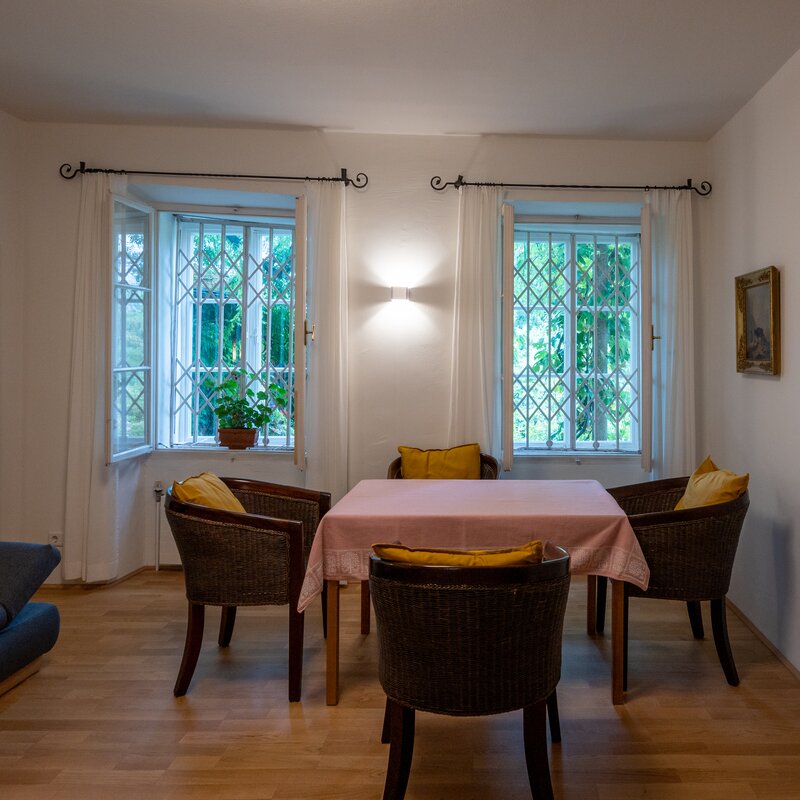 Bright dining area with rattan chairs & parquet – 2-room apartment, short-term rental & temporary housing 1 to 6 months, Salzburg