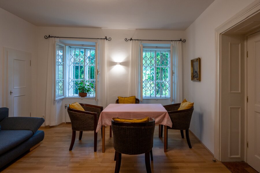 Bright dining area with rattan chairs & parquet – 2-room apartment, short-term rental & temporary housing 1 to 6 months, Salzburg