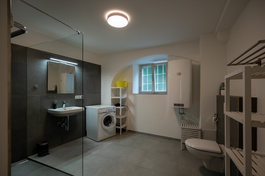 Badezimmer mit Dusche und Waschmaschine