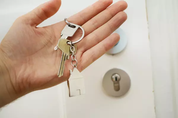 Schlüsselbund in einer offenen Hand vor der Wohnungstür | © Maria Ziegler