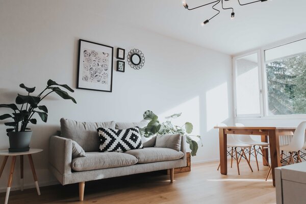 Wohnzimmer mit Blick zur Couch in weiß gehalten - puristisch | © OCNSMedia