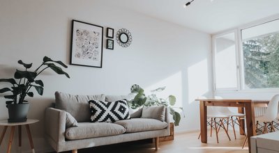 Wohnzimmer mit Blick zur Couch in weiß gehalten - puristisch | © OCNSMedia