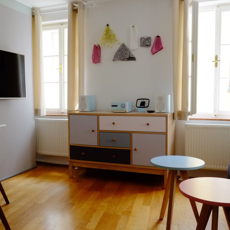 Heller Wohnbereich mit TV, Kommode & Couch – 2-Zimmer-Wohnung zur Kurzzeitmiete, Wohnen auf Zeit 1 bis 6 Monate, Salzburg